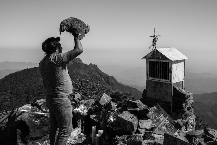 A Mixe man performs pre-hispanic rituals to send spiritual help to his brother who has migrated north. Tamazulapam del Espiritu Santo, Oaxaca, Mexico.